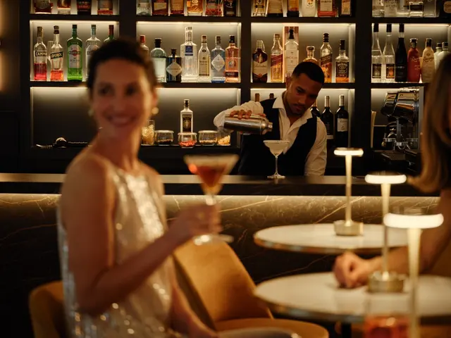 Bartender preparing a cocktail at the black marble bar of La Fonda de los Príncipes