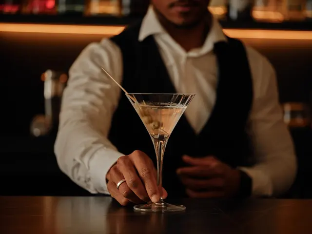 Bartender servant un martini avec olive sur le comptoir en marbre de La Fonda de los Príncipes