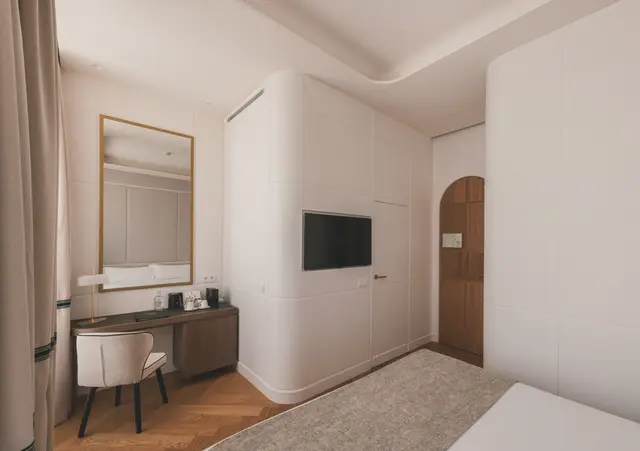 Escritorio con espejo y Smart TV frente a la cama y la puerta en arco de la Deluxe Exterior