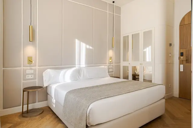 Deluxe Lateral Sol room with bed, tall upholstered headboard and mirrored wardrobe
