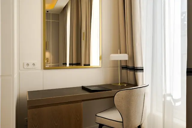 Desk with gold-framed mirror and designer lamp in Deluxe Lateral Sol room