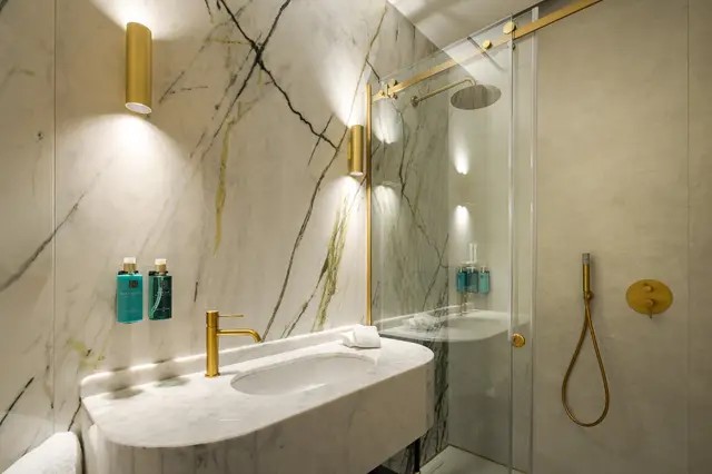 Marble bathroom with gold tap and shower and Rituals amenities in Deluxe Sol View room
