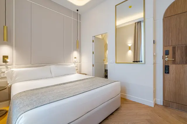 Deluxe Sol-Blick-Zimmer mit Bett, gepolstertem Kopfteil und gewölbter Holztür