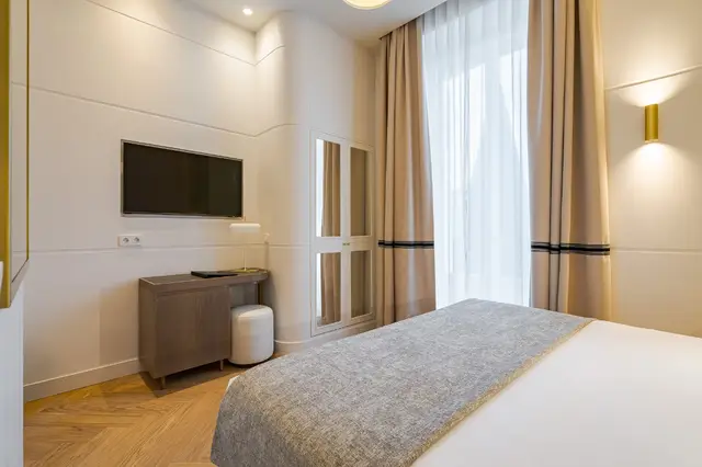 Desk area with Smart TV, mirrored wardrobe and window in Deluxe Sol View room