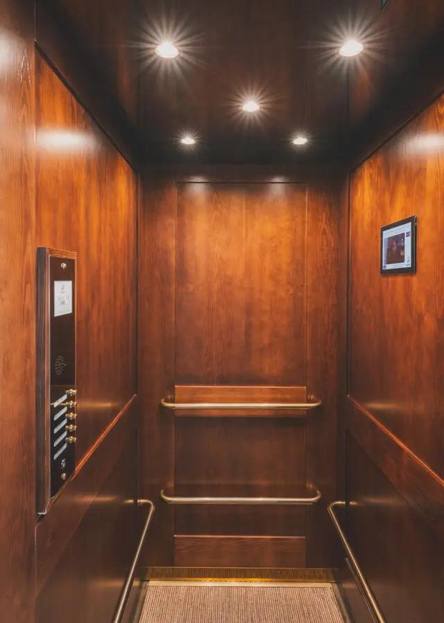 Interior of the hotel's wooden lift, with spotlights in the ceiling