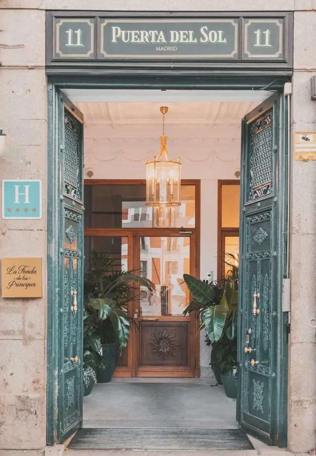 Entrada del hotel por el número 11 de la Puerta del Sol, con las puertas verdes abiertas