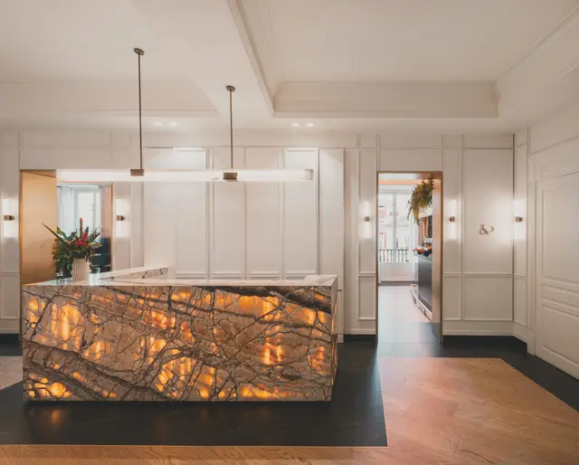 Vestíbulo del hotel con el mostrador de recepción de mármol y lámparas colgantes