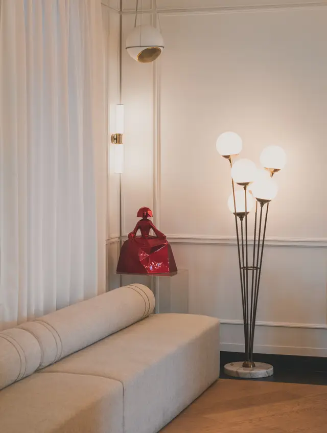 Lobby with an upholstered sofa, a floor lamp and light curtains