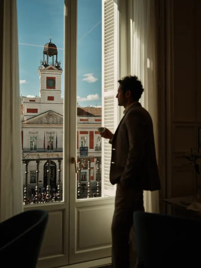 Homme savourant un café avec vue directe sur l'horloge de la Real Casa de Correos à La Fonda de los Príncipes