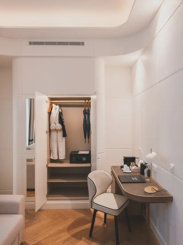 Armario abierto, escritorio y silla de la zona de trabajo en la Junior Suite Interior Familiar