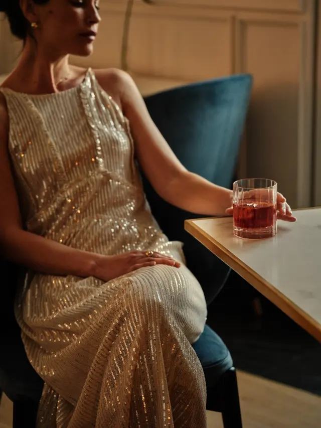 Elegant woman in sequin dress with a negroni at the restaurant of La Fonda de los Príncipes
