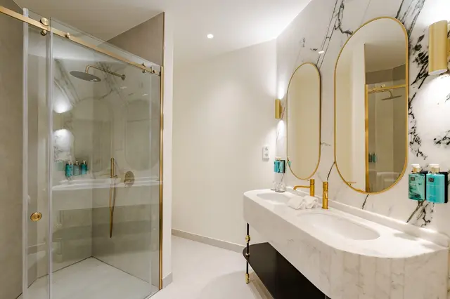 Marmorbad mit Regendusche und ovalen Spiegeln im Premium Corner mit Badewanne