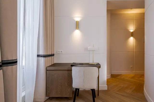 Schreibtischbereich mit Lampe und Schlafzimmerzugang im Premium Corner mit Badewanne