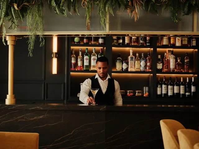 Bar lounge with guests and bar counter in the background in the evening at La Fonda de los Príncipes