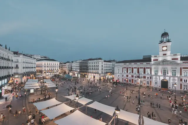 Panorámica de la Puerta del Sol en la hora azul con los toldos de la plaza