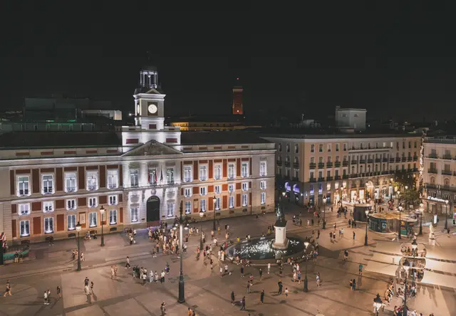 La plaza de la Puerta del Sol de noche con la Real Casa de Correos iluminada
